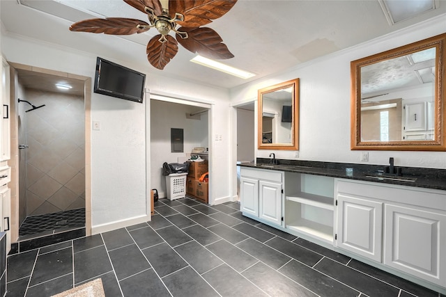 full bath featuring double vanity, a walk in shower, a ceiling fan, and a sink