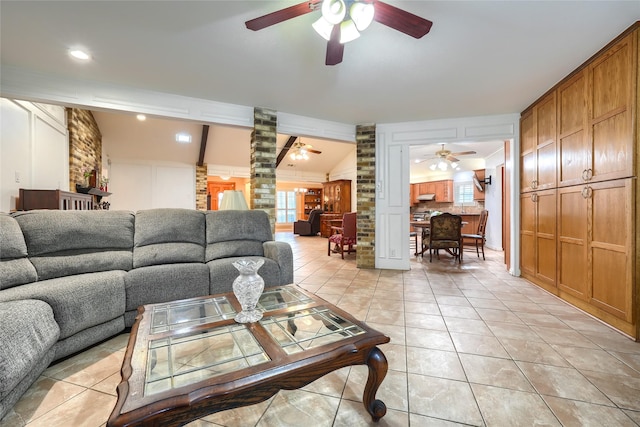 living area featuring light tile patterned floors, a ceiling fan, ornate columns, and lofted ceiling