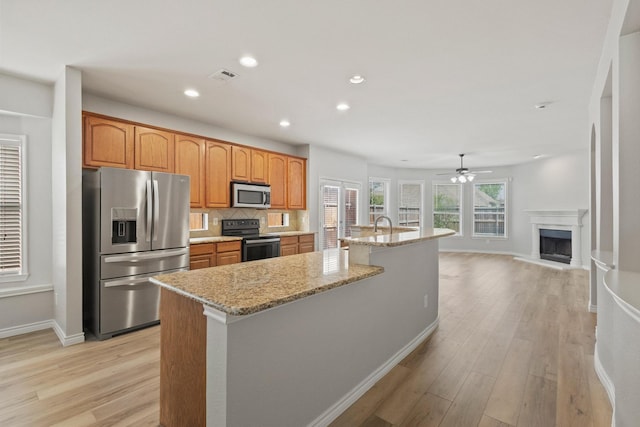 689 Bonham Dr, Lavon, TX 75166 - kitchen featuring baseboards, light wood-style flooring, appliances with stainless steel finishes, and light stone countertops