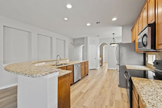 689 Bonham Dr, Lavon, TX 75166 - kitchen with light wood-type flooring, arched walkways, a sink, and appliances with stainless steel finishes