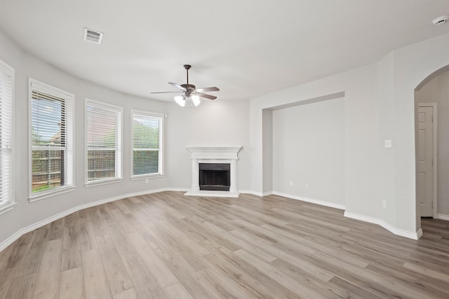 689 Bonham Dr, Lavon, TX 75166 - unfurnished living room with arched walkways, ceiling fan, light wood finished floors, and visible vents