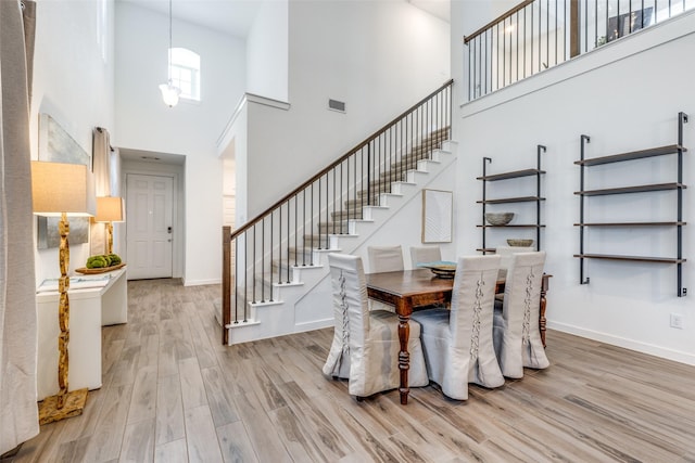 1213 Shire, Aubrey, TX 76227 - dining room featuring visible vents, wood finished floors, stairway, and a towering ceiling