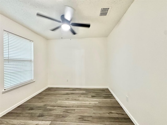 unfurnished room with baseboards, a ceiling fan, wood finished floors, and visible vents