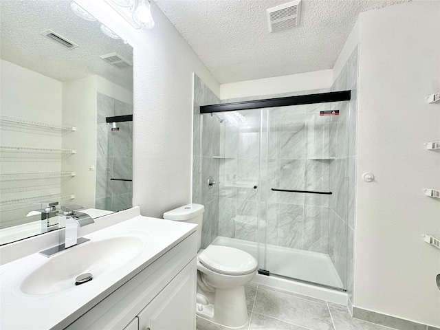 bathroom with a stall shower, a textured ceiling, and visible vents