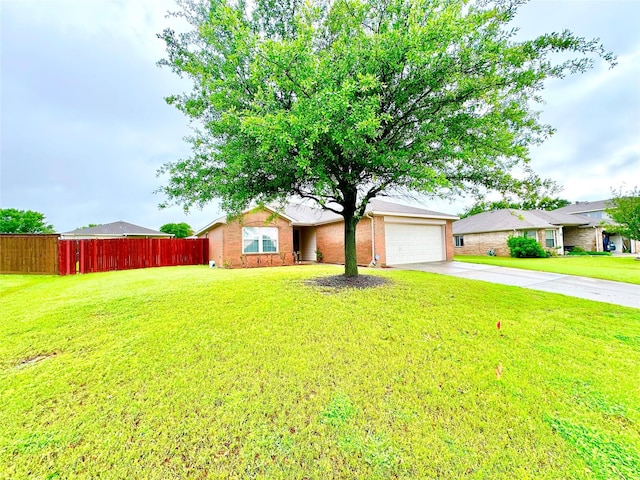 view of front of house featuring driveway, a front yard, brick siding, fence, and an attached garage