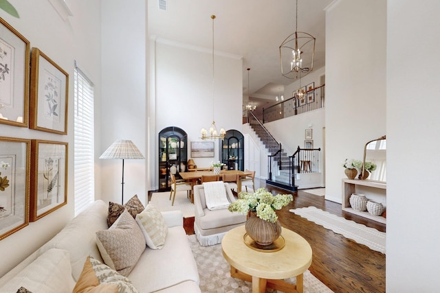 5936 Augustine Rd, Mckinney, TX 75071 - living area featuring a chandelier, a towering ceiling, wood finished floors, stairway, and baseboards