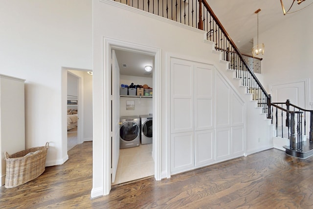 interior space with separate washer and dryer, dark wood-style flooring, a high ceiling, and stairway