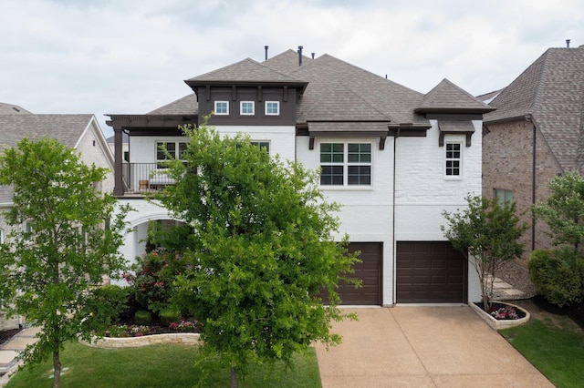 exterior space with a yard, a garage, brick siding, concrete driveway, and a shingled roof