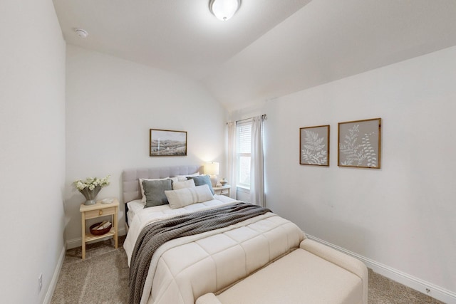 carpeted bedroom featuring baseboards and vaulted ceiling