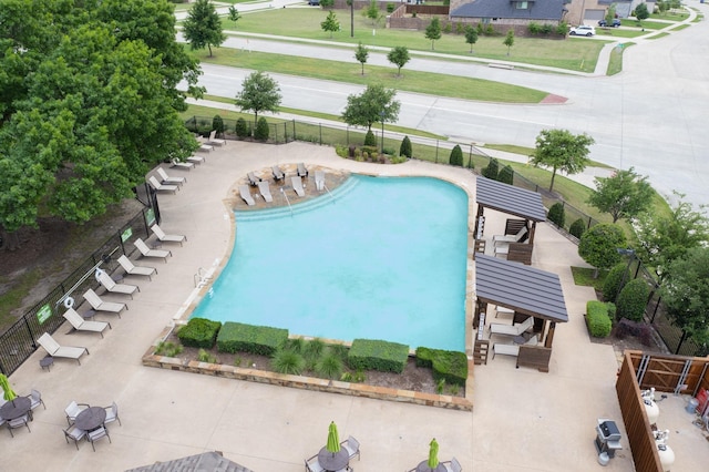 community pool with fence and a patio