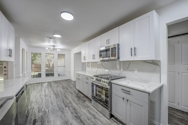 1441 Marlene Pl, Desoto, TX 75115 - kitchen with decorative backsplash, visible vents, appliances with stainless steel finishes, an inviting chandelier, and light wood-style flooring