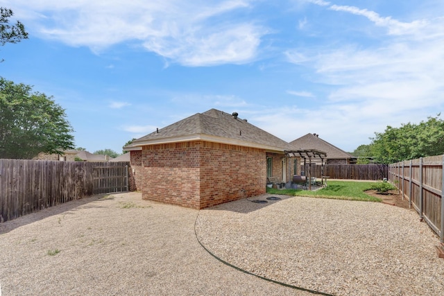 rear view of house with a patio area, brick siding, a fenced backyard, a pergola, and a shingled roof