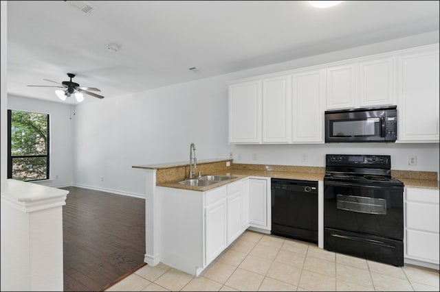 kitchen with white cabinets, ceiling fan, a sink, a peninsula, and black appliances