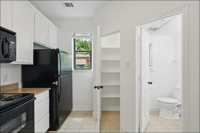 kitchen featuring light tile patterned floors, white cabinets, black appliances, and visible vents
