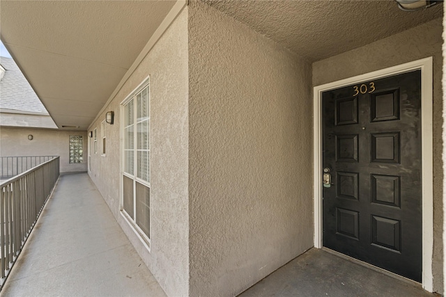 doorway to property featuring stucco siding