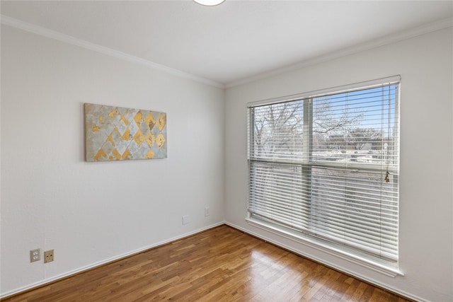 unfurnished room with baseboards, ornamental molding, and wood finished floors