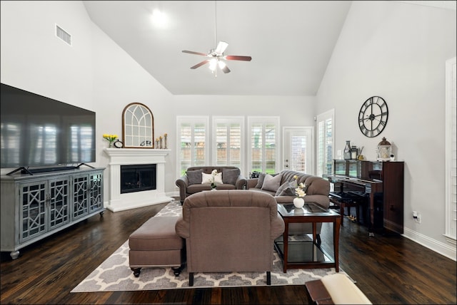 living room featuring a ceiling fan, high vaulted ceiling, visible vents, and baseboards