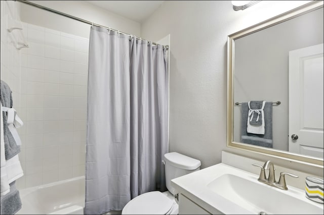 full bath featuring vanity, shower / bath combo with shower curtain, and toilet
