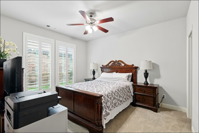 bedroom with visible vents, a ceiling fan, baseboards, and light colored carpet