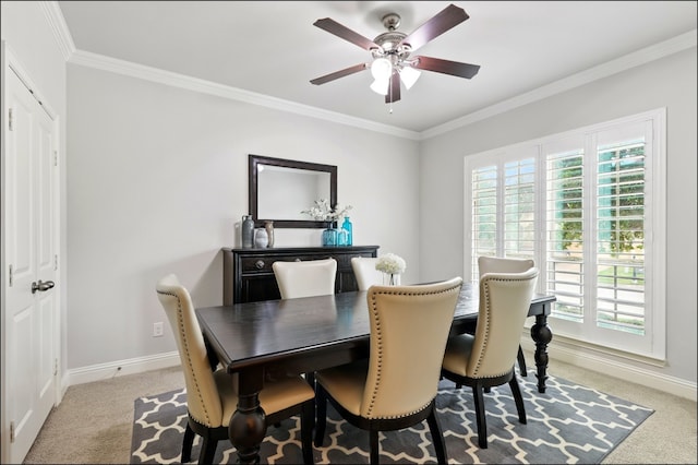 dining room featuring a healthy amount of sunlight, ornamental molding, a ceiling fan, and light colored carpet