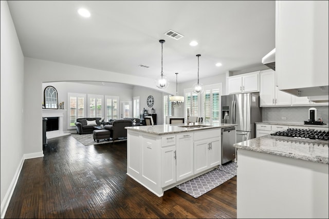 kitchen featuring a sink, white cabinetry, a center island with sink, and stainless steel appliances