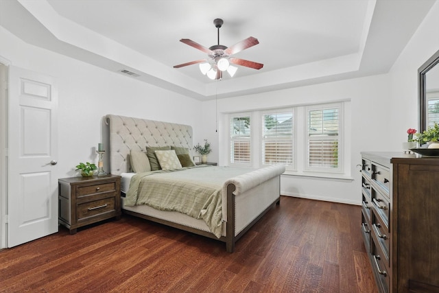 5729 New Castle Dr, Richardson, TX 75082 - bedroom featuring visible vents, a raised ceiling, ceiling fan, and dark wood-style floors