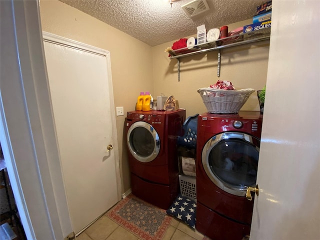 laundry area with visible vents, laundry area, a textured ceiling, and washer and dryer