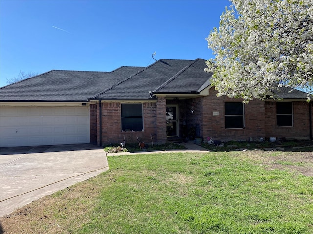 ranch-style home with a shingled roof, an attached garage, a front lawn, brick siding, and driveway