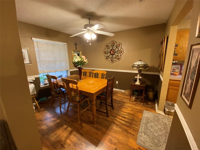 dining space with baseboards, a ceiling fan, a textured ceiling, and wood finished floors