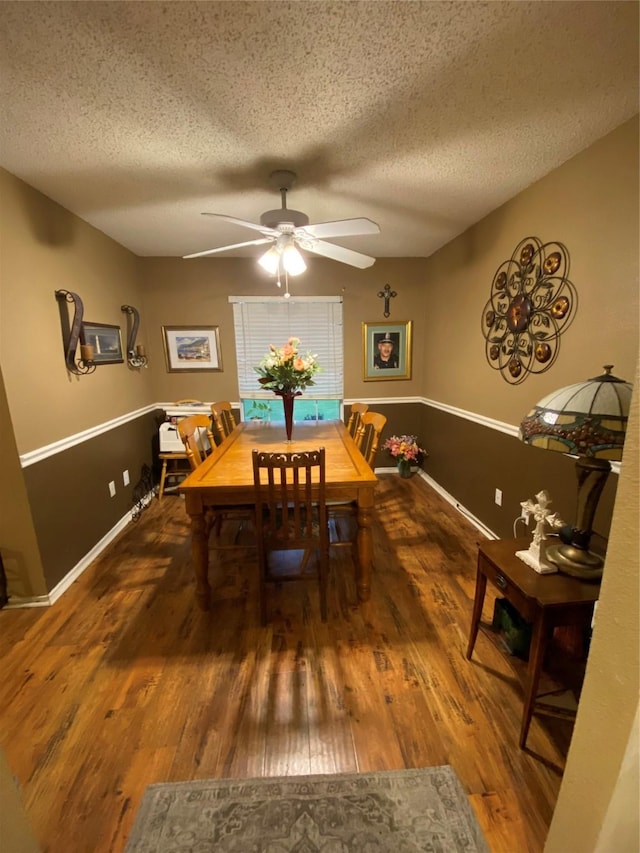 dining room featuring a textured ceiling, ceiling fan, and wood finished floors