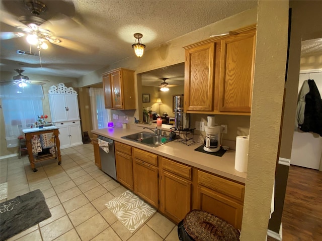 kitchen with stainless steel dishwasher, a sink, ceiling fan, and light countertops