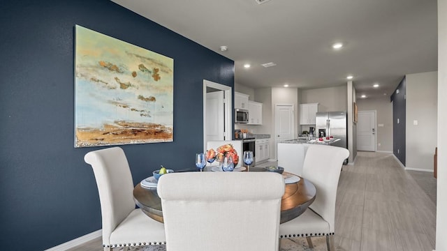 dining room featuring baseboards and recessed lighting