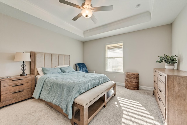 bedroom featuring crown molding, ceiling fan, light colored carpet, baseboards, and a tray ceiling