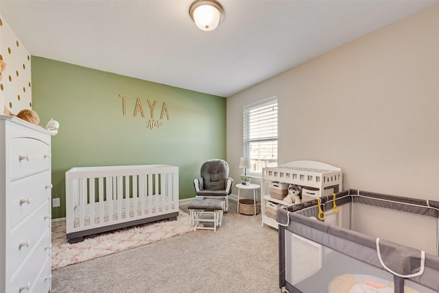 bedroom featuring carpet floors, a crib, and baseboards
