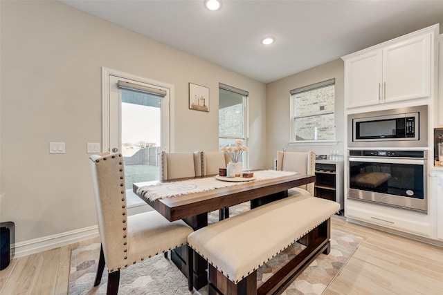 dining space featuring light wood-type flooring, recessed lighting, and baseboards