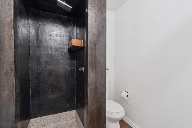 bathroom featuring toilet and baseboards