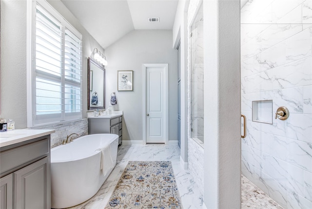 bathroom with marble finish floor, a freestanding tub, a shower stall, vaulted ceiling, and visible vents