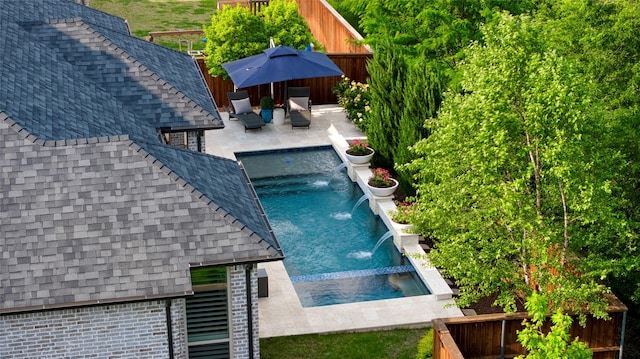 view of pool featuring an in ground hot tub, a fenced in pool, a fenced backyard, and a patio area