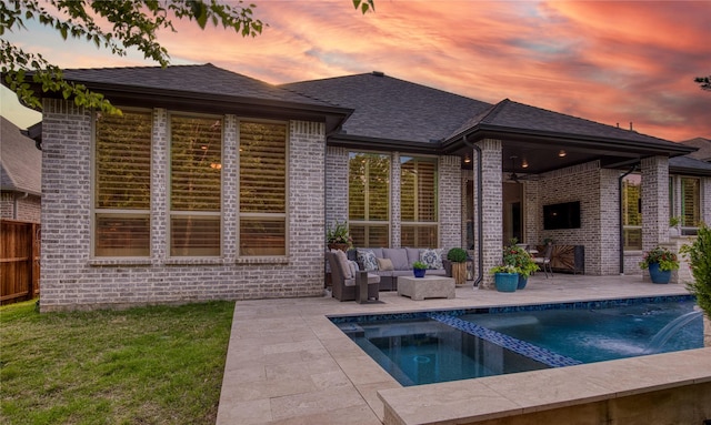 back of house with brick siding, an outdoor pool, an outdoor hangout area, and a patio