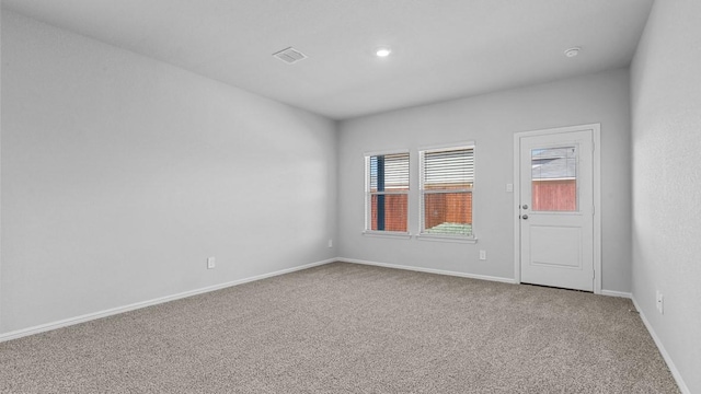 unfurnished room with carpet floors, baseboards, and visible vents
