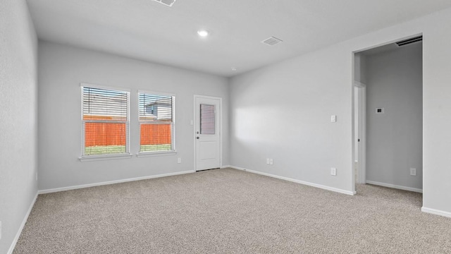empty room with carpet floors, baseboards, recessed lighting, and visible vents