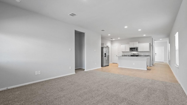 unfurnished living room featuring visible vents, recessed lighting, baseboards, and light colored carpet