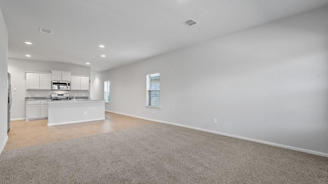 unfurnished living room featuring recessed lighting, baseboards, and visible vents