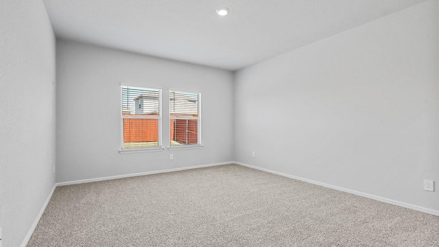 carpeted empty room with baseboards