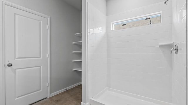 full bathroom featuring baseboards, a shower stall, and tile patterned flooring
