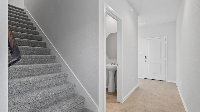 stairway with tile patterned floors and baseboards