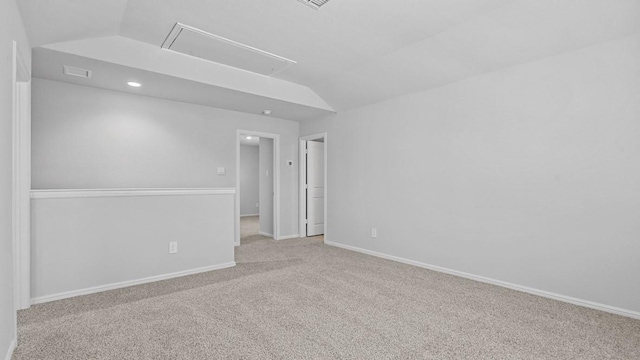 unfurnished room with baseboards, attic access, carpet flooring, and visible vents
