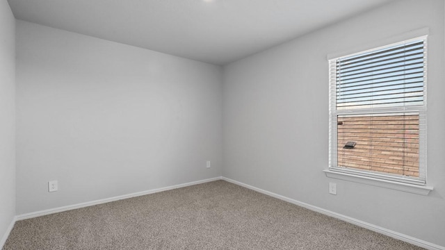 carpeted spare room with baseboards and a wealth of natural light