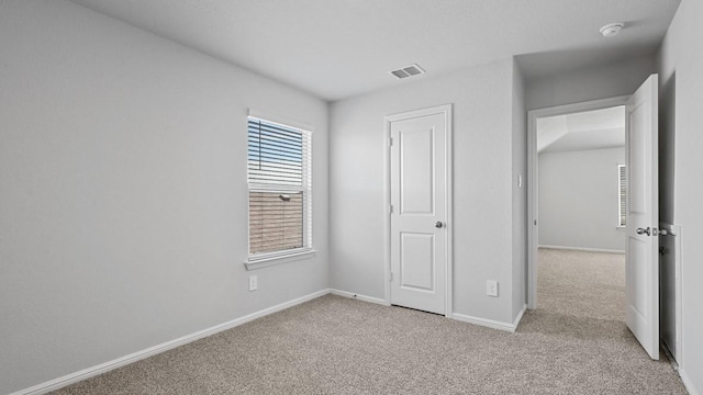 unfurnished bedroom with baseboards, visible vents, and carpet
