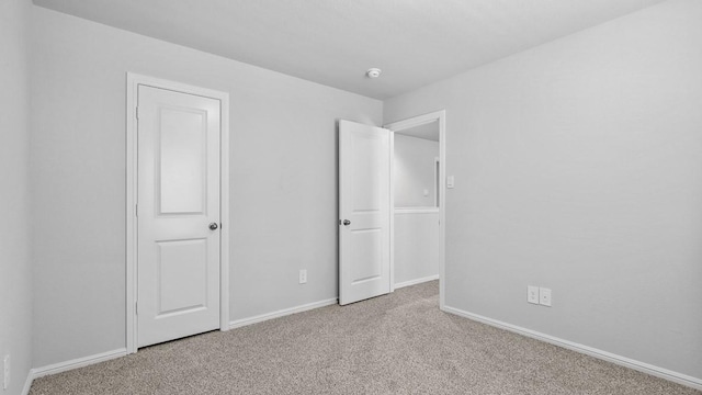 unfurnished bedroom featuring baseboards and carpet flooring